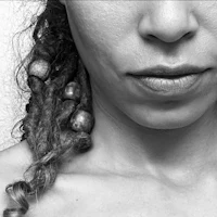 a black and white photo of a woman with dreadlocks